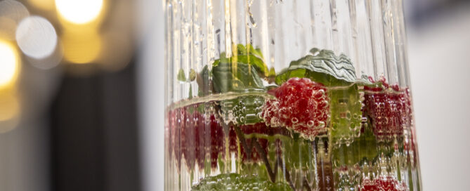 Wasserkrug mit Himbeeren und Minze